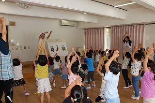 保育士と子ども達が体操をしている