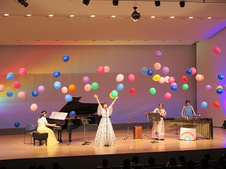 風船が舞うステージで出演者が演奏している様子