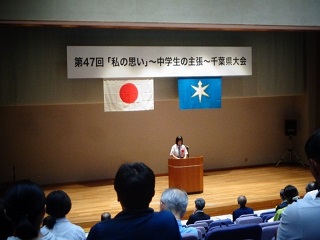 松尾さんがステージでスピーチをしている。