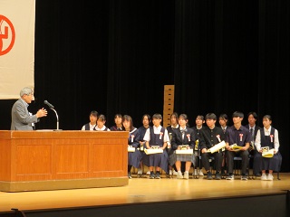 表彰式で講評を述べる審査委員長とそれを聞く発表者の様子