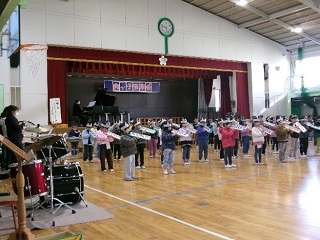 体育館で1年生児童が鍵盤ハーモニカを吹く様子。