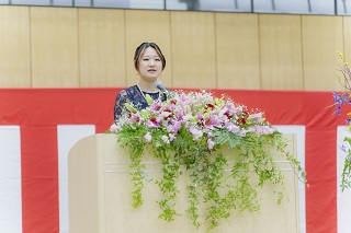 壇上で話す成人式実行委員長の島ノ江さんの写真