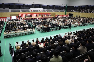 2階から撮影された会場全体の写真。多くのパイプ椅子が用意され、参加者が座っている様子。