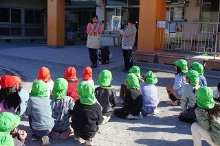 3・4・5歳児が園庭に集まり、節分の由来をスケッチブックシアターを用いて聞いています。