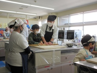 初めに、厚手のビニール板の上から足で踏んで生地の形を整える「足踏み」を行いました。