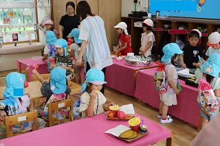 子ども達が食べ物屋でお店屋さん役とお客さん役に分かれて楽しんでいる