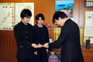 教育長にお金を手渡す生徒会長
