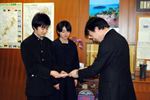 教育長にお金を手渡す生徒会長