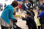 新1年生が制服制帽姿で交通安全を呼びかけている様子の写真