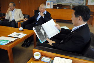 寄贈された本を見る井崎市長の写真