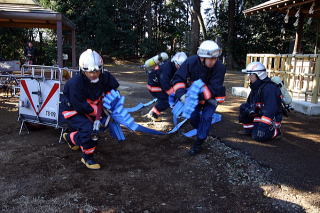 ホースを延ばす消防隊