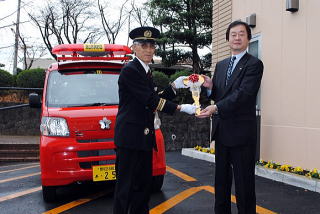 消防車の前での加藤団長の写真