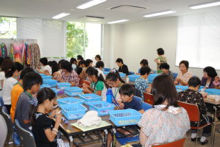 折鶴の糸通しをする子ども達の写真