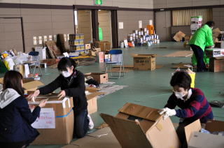 仕分け作業に参加している多数のボランティアの写真