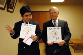 サインと目録を手にする松本施設長と鈴木さん