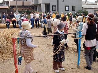 3本の綱で藁を締めていく様子の写真