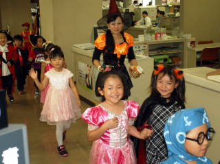 市役所をハロウィンの衣装で行進する子どもたち