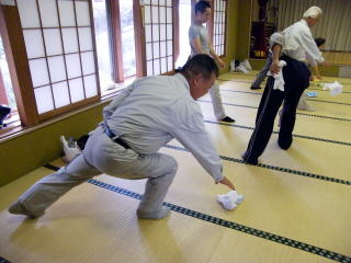 前傾姿勢でタオルを拾う体操の写真