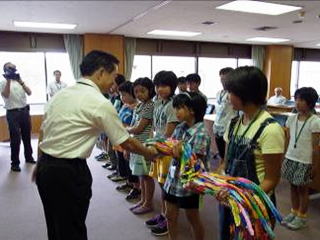 井崎市長から千羽鶴を手渡される平和大使