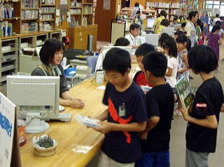 カウンターで本を借りる子どもたち