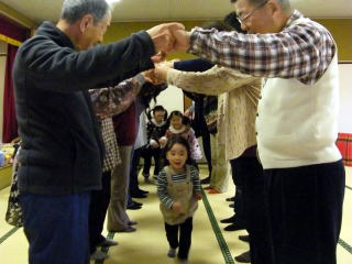 大人の作ったトンネルを走る子どもたちの写真