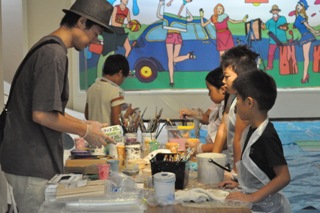 画家の傍嶋賢さんの指導で絵を描く子どもたち