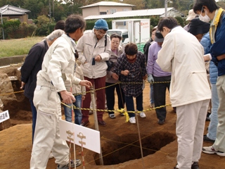 縄文人が掘った落とし穴を覗く見学者の皆さん