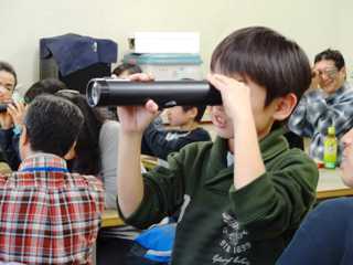望遠鏡を覗きこむ小学生