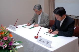 調印する市村学長と井崎市長