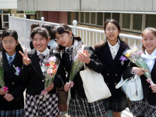 受け取った花束を胸に記念撮影