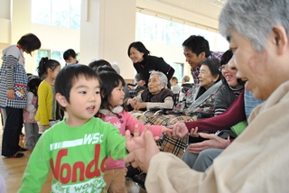 子どもたちがお年寄りたちと握手でお別れ