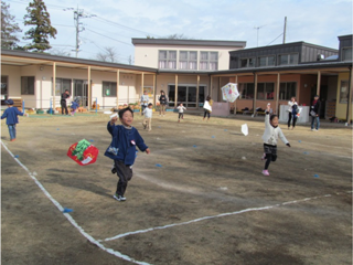 園庭で凧をあげる子どもたち