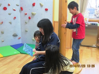 高校生に絵本を読んでもらう子どもたち