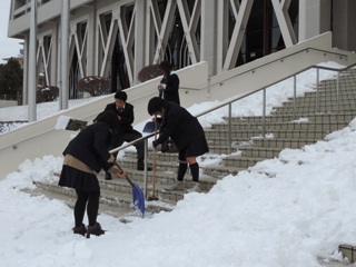 雪かきをする高校生