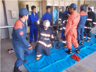 防火衣と空気呼吸器の着装を体験