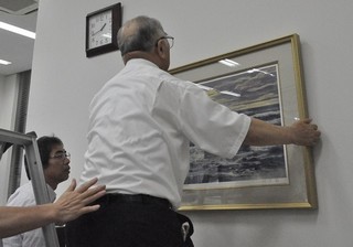 出張所の壁に絵画を取り付け