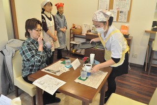 飲み物をお客さんに出す高校生