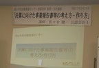 スクリーンでテーマ「決算に向けた事業報告書等の考え方・作り方」を紹介