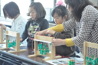 小さなお子さんを手伝う博物館スタッフの写真