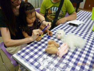 お母さんと一緒に作業する女の子の写真