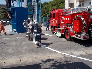 消防車からホースを繰り出している様子の写真