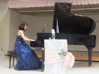 ピアノと江崎さんを横から写した写真