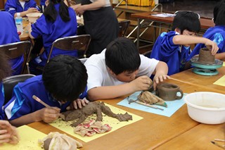 変わった生き物のオブジェを作る生徒の写真