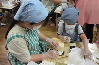 子どもが太巻きを作っている写真