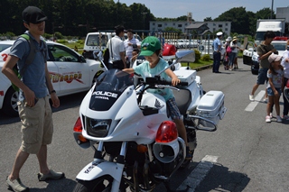 大型バイクにまたがらせてもらう子どもの写真