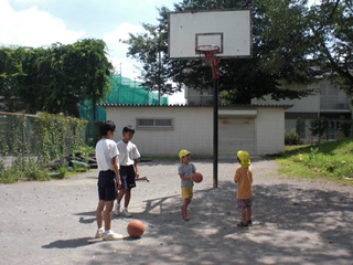 バスケットゴールで遊ぶ子どもたちの写真