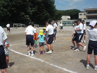 校庭で鬼ごっこをする子どもたちの写真