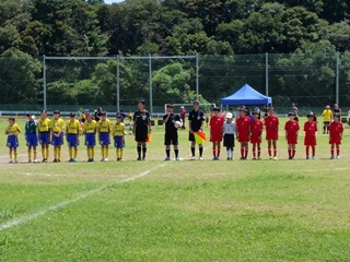 サッカー場で整列する選手たちの写真