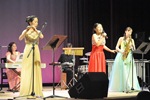 色とりどりのドレスを着て演奏するプラスワンのメンバーの写真