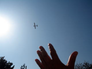 青空の中を飛ぶセスナ機